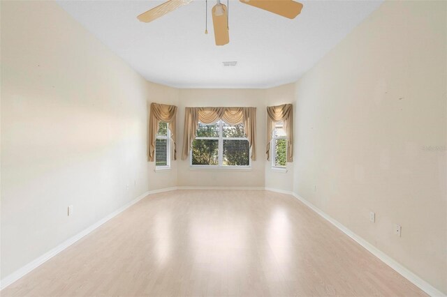 empty room with ceiling fan and light hardwood / wood-style flooring