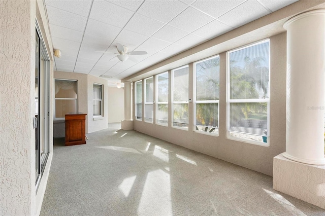 unfurnished sunroom with ceiling fan and ornate columns