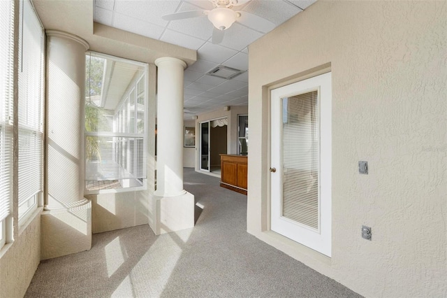 corridor with a paneled ceiling, carpet flooring, and decorative columns