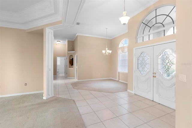 tiled foyer featuring french doors, an inviting chandelier, and ornamental molding