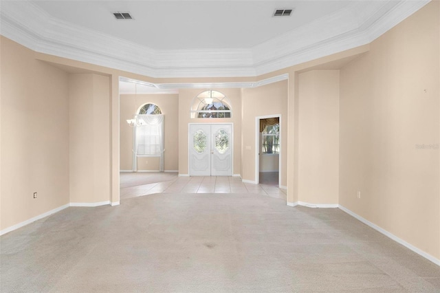 carpeted spare room with crown molding and french doors