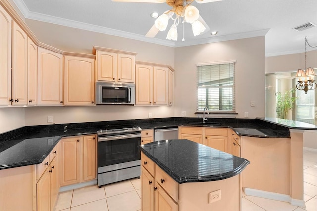 kitchen with light brown cabinetry, sink, a center island, and appliances with stainless steel finishes