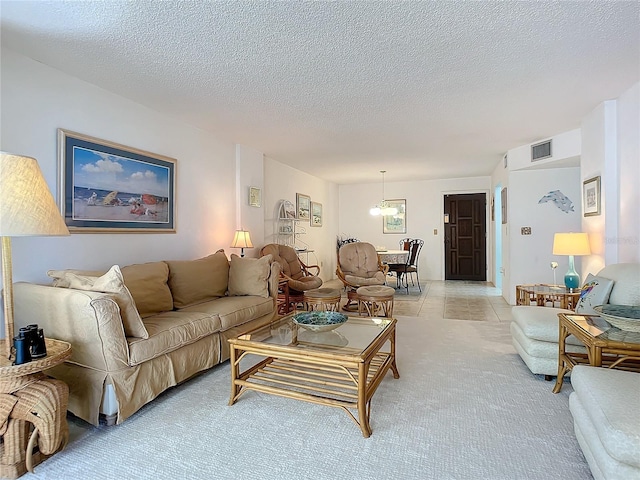 living room with light colored carpet, a notable chandelier, and a textured ceiling