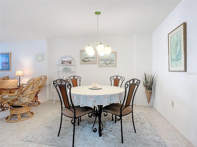 tiled dining area featuring an inviting chandelier and a textured ceiling