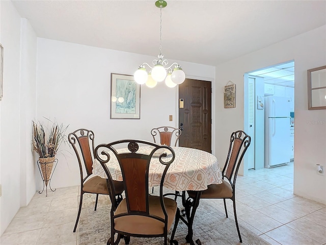 dining space featuring light tile floors and an inviting chandelier