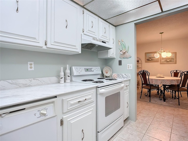 kitchen featuring white appliances, light tile flooring, white cabinets, pendant lighting, and a chandelier