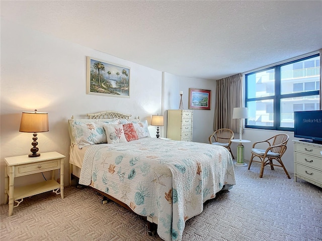 bedroom with light carpet and a textured ceiling