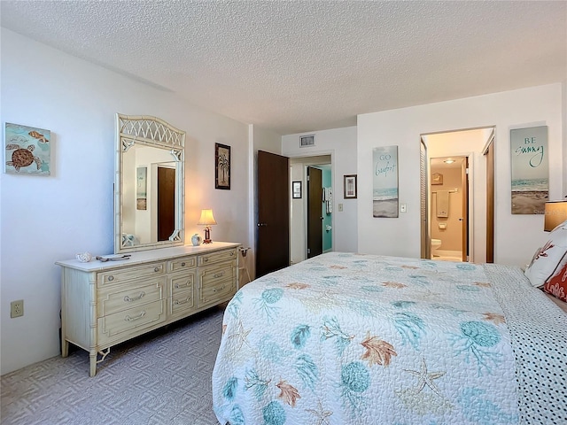 bedroom featuring a textured ceiling, dark colored carpet, and connected bathroom