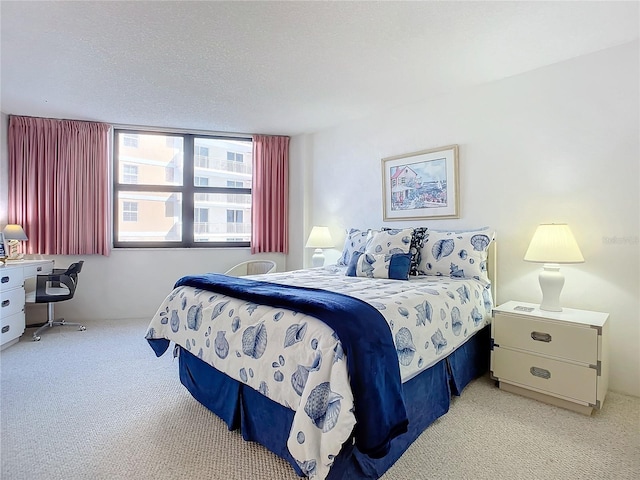 bedroom with light carpet and a textured ceiling