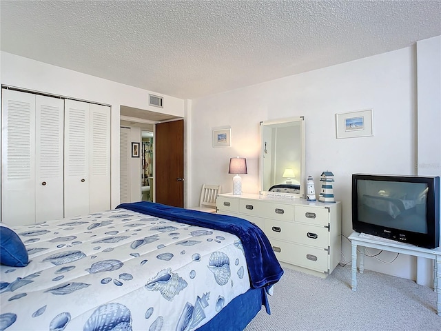 bedroom with a closet, a textured ceiling, and light carpet
