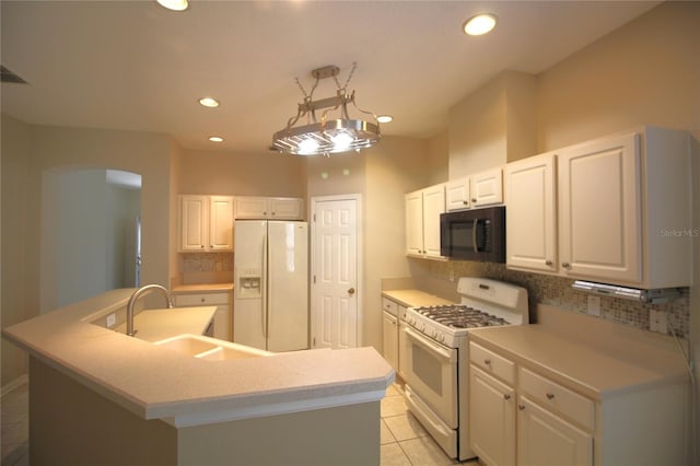 kitchen featuring white appliances, tasteful backsplash, light tile floors, and a kitchen island with sink