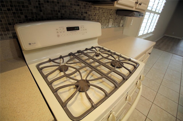 interior space with white range, tasteful backsplash, light wood-type flooring, and white cabinetry