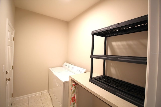 washroom featuring light tile floors and washer and dryer