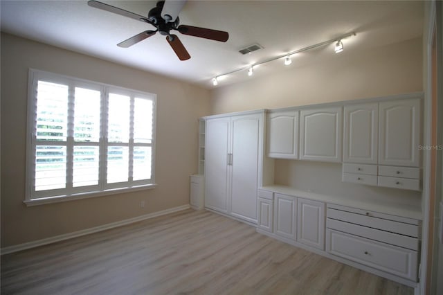 interior space with light wood-type flooring, ceiling fan, and track lighting