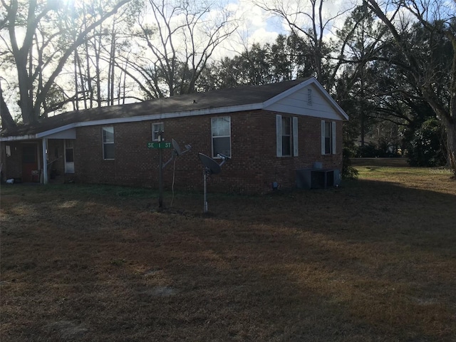 exterior space featuring a front yard and central AC