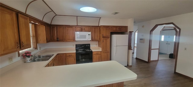 kitchen featuring hardwood / wood-style floors, sink, white appliances, and kitchen peninsula