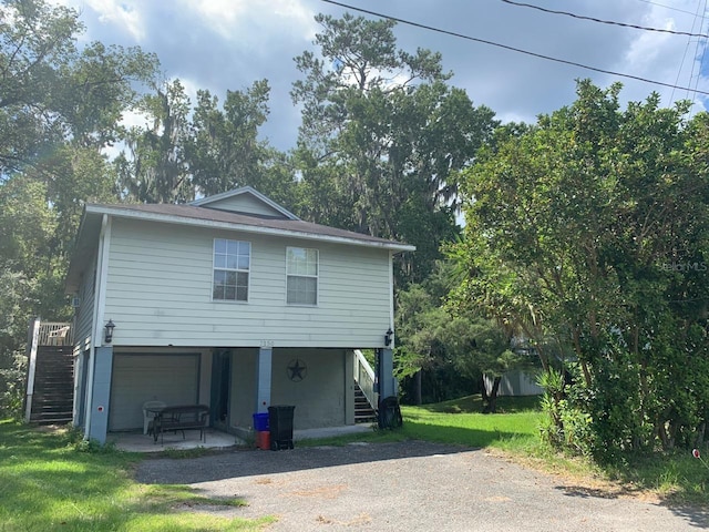 back of property featuring a garage and a lawn