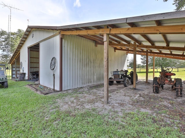 exterior space featuring a lawn, a carport, and an outdoor structure