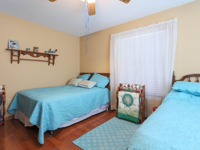 bedroom with wood-type flooring, ceiling fan, and a textured ceiling