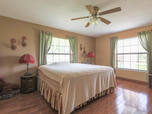 bedroom with a textured ceiling, ceiling fan, and hardwood / wood-style floors