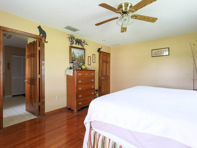 bedroom featuring a textured ceiling, hardwood / wood-style floors, and ceiling fan