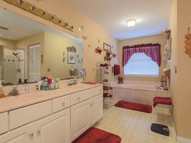 bathroom with a textured ceiling, double sink vanity, shower with separate bathtub, and tile flooring