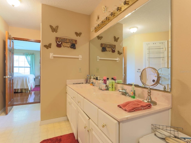 bathroom with tile floors, oversized vanity, and a textured ceiling