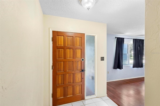 entrance foyer with a textured ceiling and light hardwood / wood-style floors