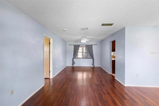 empty room featuring dark hardwood / wood-style flooring, a textured ceiling, and ceiling fan