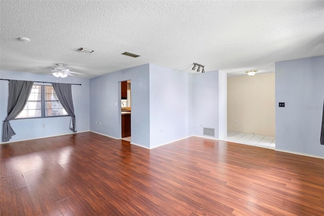 spare room with hardwood / wood-style floors, a textured ceiling, and ceiling fan