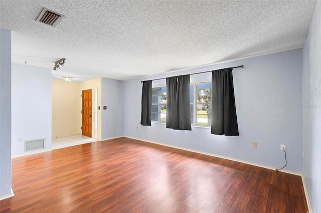 unfurnished room featuring light hardwood / wood-style floors and a textured ceiling