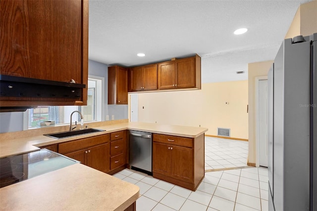 kitchen featuring kitchen peninsula, appliances with stainless steel finishes, sink, and light tile patterned floors