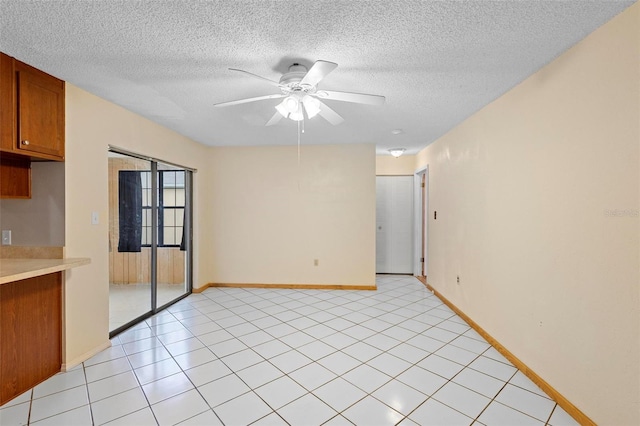 tiled empty room featuring a textured ceiling and ceiling fan