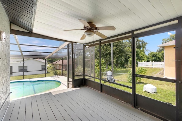 exterior space featuring ceiling fan, a lanai, a yard, and a deck