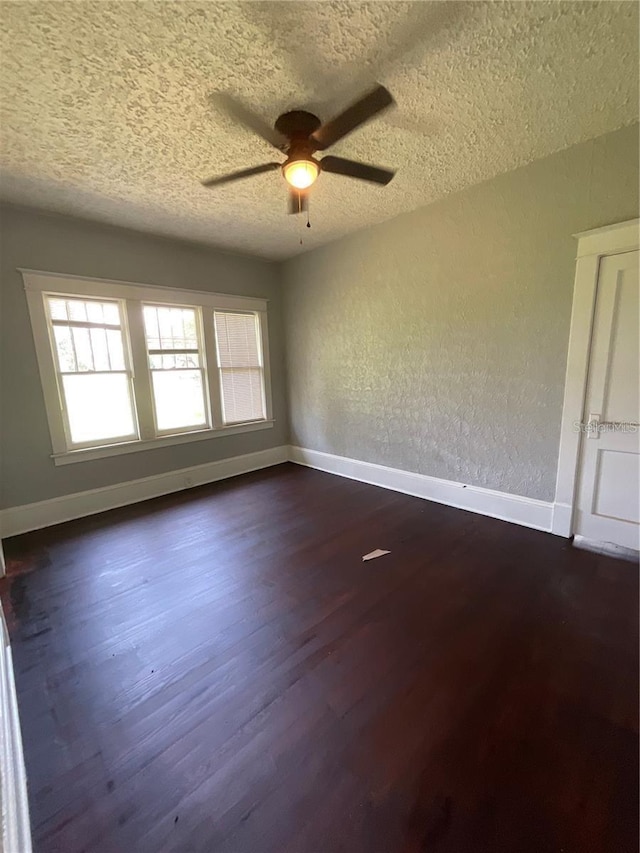 spare room with dark wood-type flooring, ceiling fan, and a textured ceiling