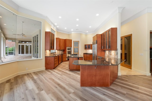 kitchen featuring ceiling fan, kitchen peninsula, backsplash, and light wood-type flooring