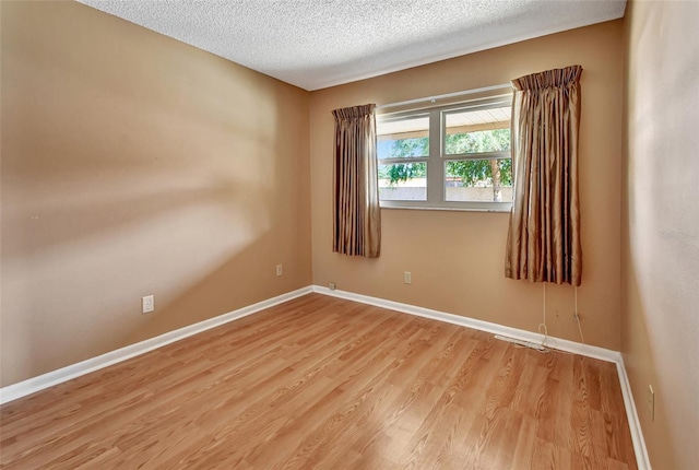 empty room featuring light hardwood / wood-style floors and a textured ceiling