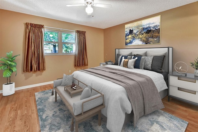 bedroom with a textured ceiling, wood-type flooring, and ceiling fan