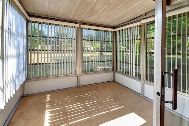 unfurnished sunroom featuring a healthy amount of sunlight, vaulted ceiling, and wooden ceiling