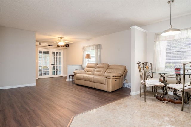 living room featuring ceiling fan, a textured ceiling, hardwood / wood-style floors, and french doors