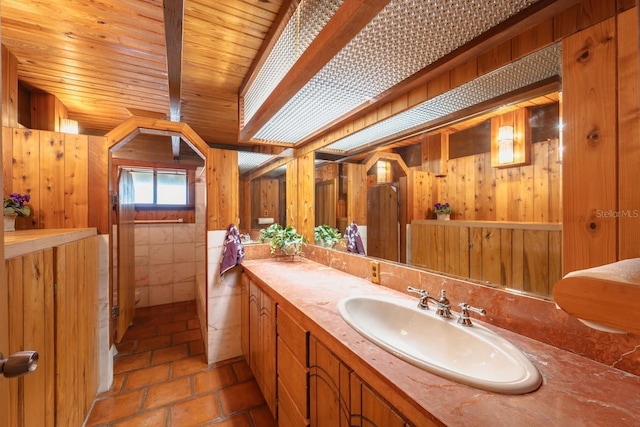 bathroom featuring tile patterned flooring, vanity, wooden ceiling, and wood walls