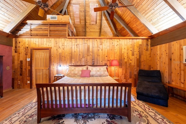 bedroom with lofted ceiling with beams, wooden ceiling, wooden walls, and light hardwood / wood-style flooring