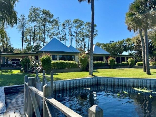 view of dock with a yard and a water view