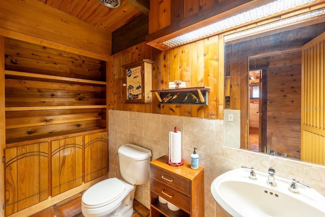 bathroom featuring wood walls, sink, wood ceiling, and toilet