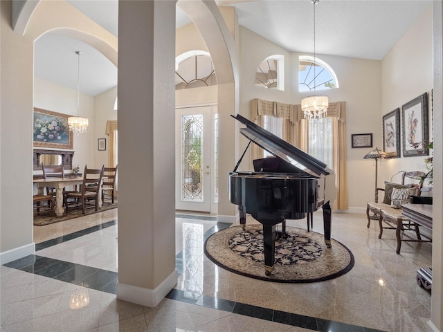 entrance foyer with a high ceiling, plenty of natural light, tile flooring, and a notable chandelier