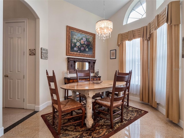 dining room with high vaulted ceiling, an inviting chandelier, and light tile floors