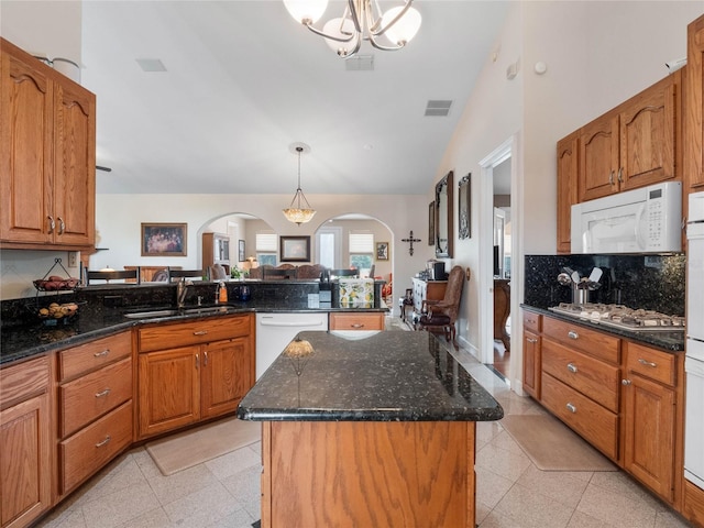 kitchen featuring a kitchen island, sink, white appliances, and light tile floors