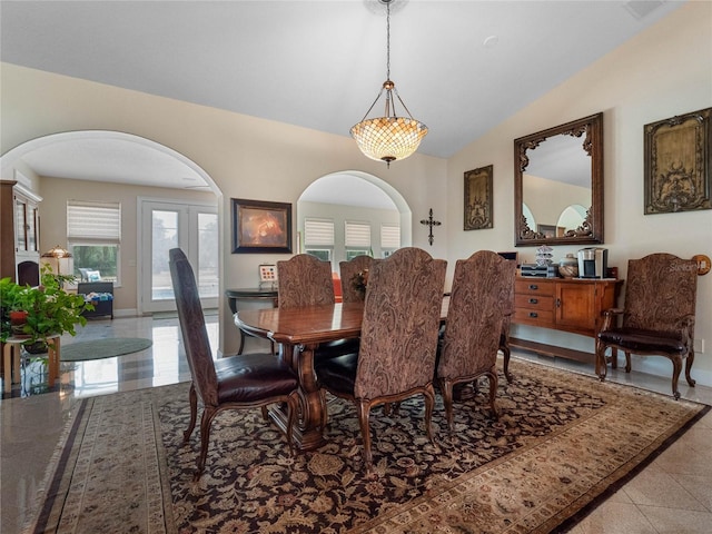 dining area featuring tile floors and lofted ceiling