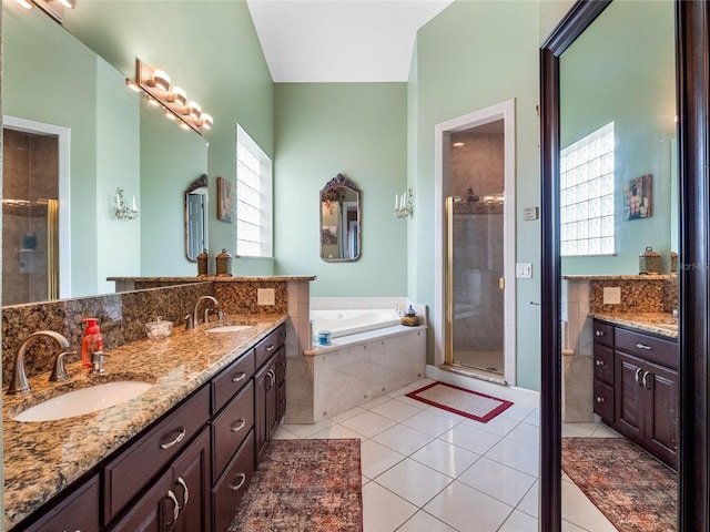 bathroom featuring tile floors, a healthy amount of sunlight, double vanity, and plus walk in shower