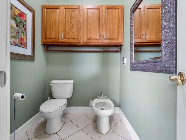 bathroom with a bidet, tile floors, and toilet